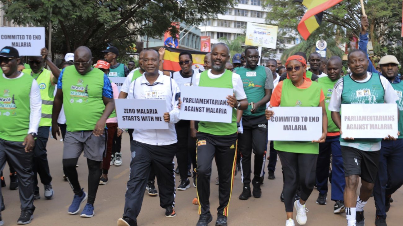 Members of Parliament in green Walk Against Malaria vests march through Kampala holding signs reading Parliamentarians Against Malaria and Zero Malaria Starts With Me