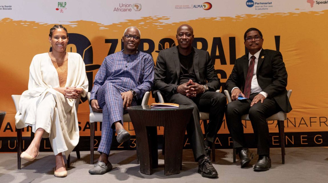 Four speakers seated on stage in front of an orange Zero Malaria banner at the fifth anniversary celebration in Dakar, Senegal