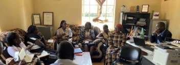 MYCU and Ministry of Health team seated in an office meeting with the district health team