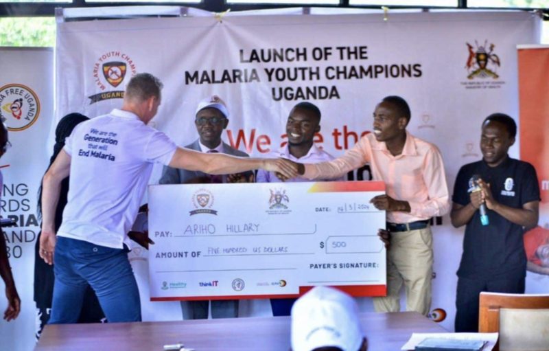 Hilary Ariho receives a 500 US dollar award cheque at the launch of Malaria Youth Champions Uganda